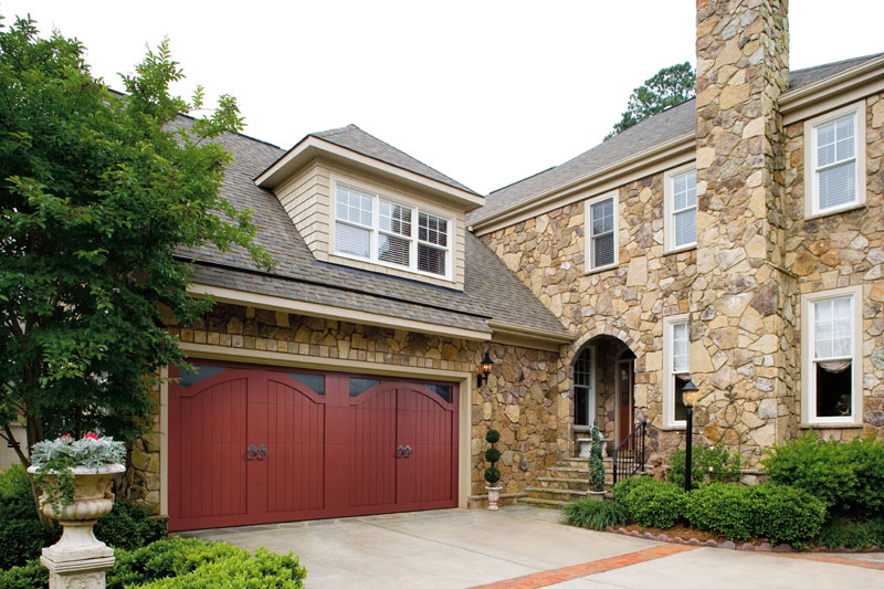 A curbside view of a red, two-car garage door installation in Olathe