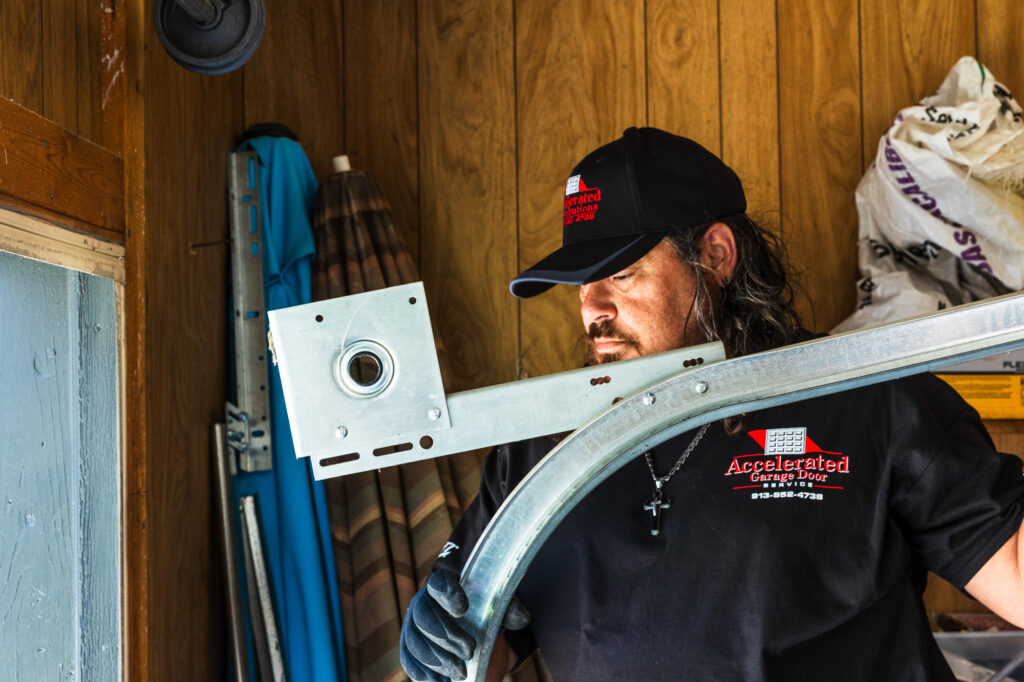 A member of our team with a piece of track in his hands for a complete garage door refurbishment in Merriam.