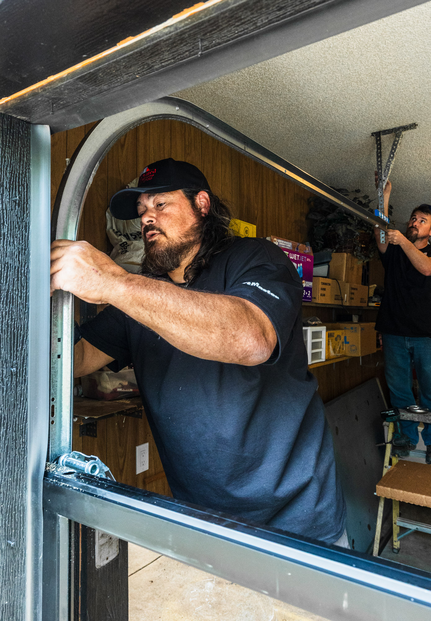 Garage door technician placing tracks onto the garage door